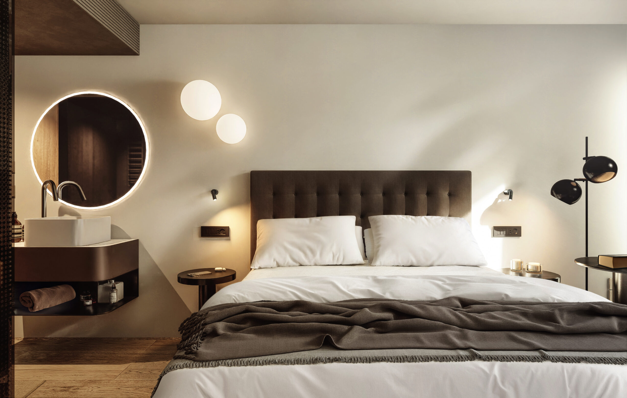 The Planika Room in daylight: a double bed with a dark upholstered headboard, a round backlit mirror and a stone washbasin